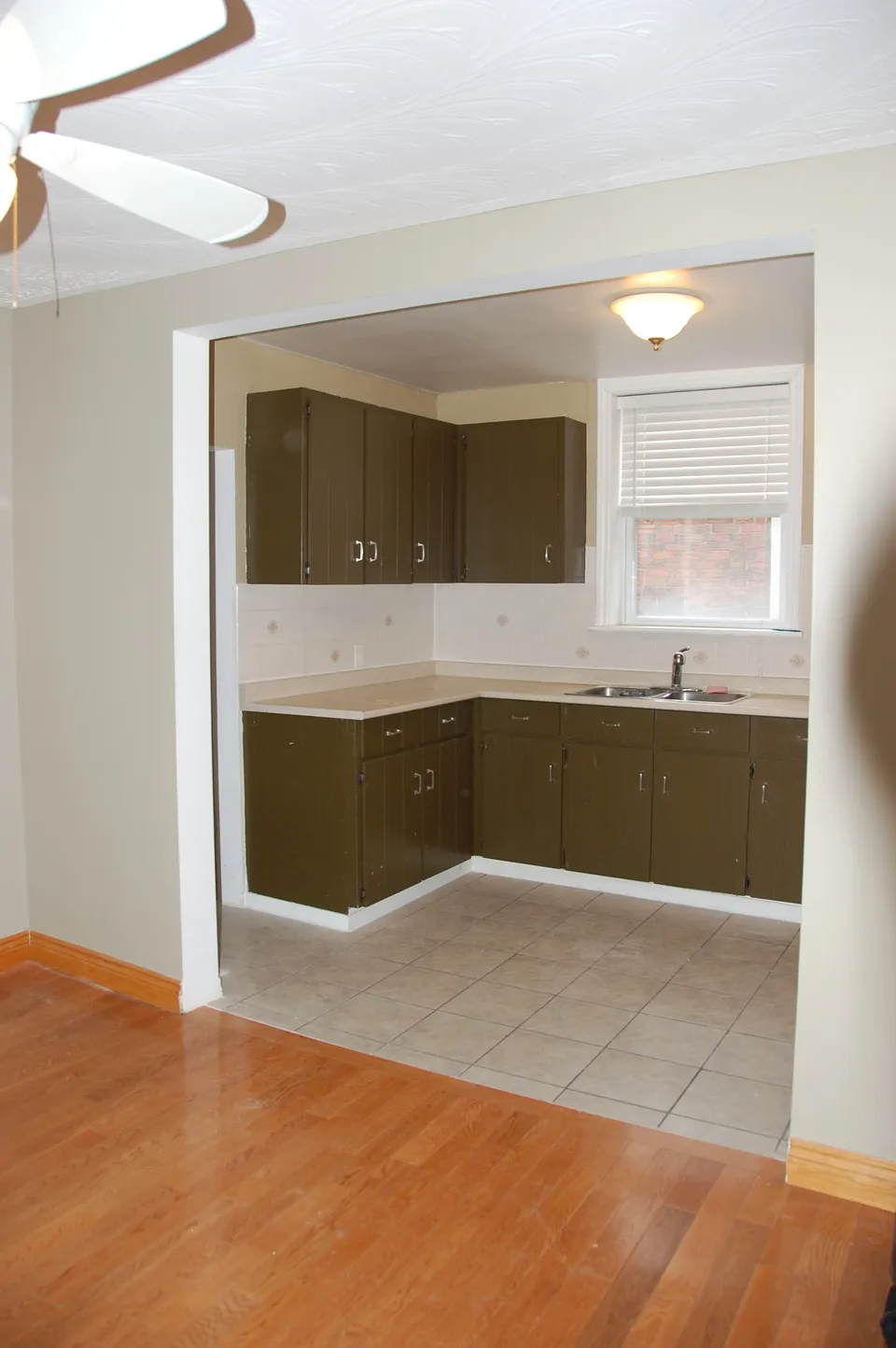 Before: darker cabinetry and older finishes, seen through a compact opening from the adjoining room.