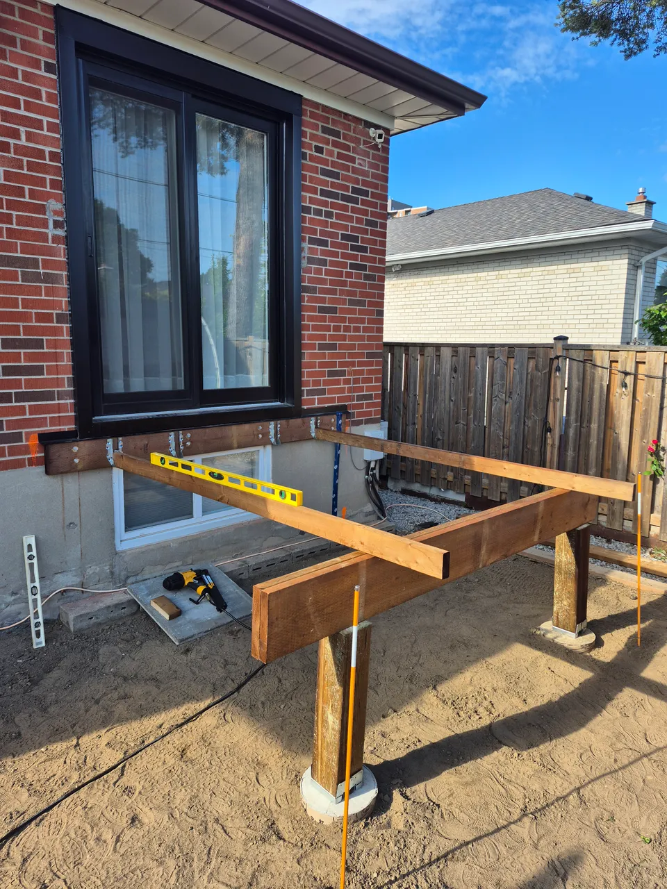 Timber deck framework taking shape in front of the patio door.