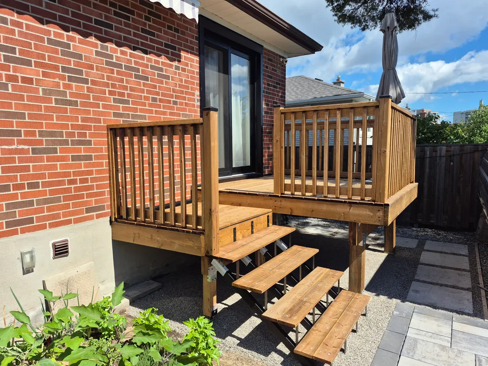 After: a patio door opening onto a timber deck with railings and stairs leading down to the yard.